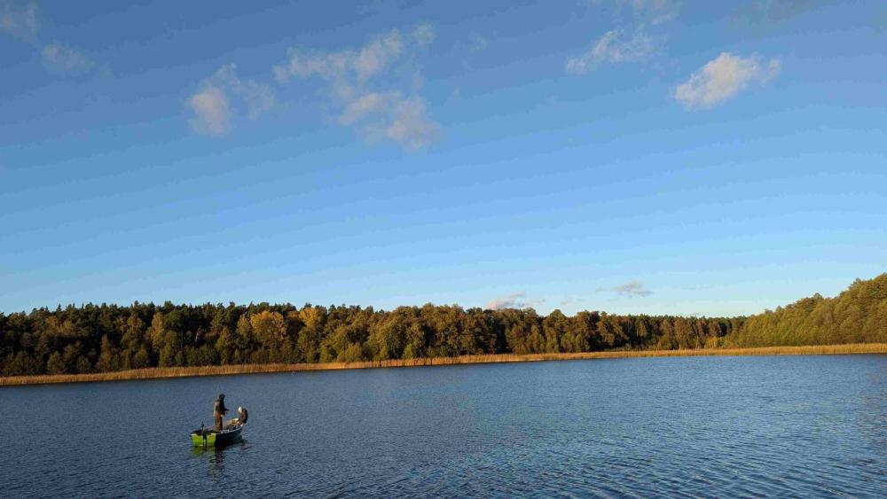 A fisherman on a boat on a lake